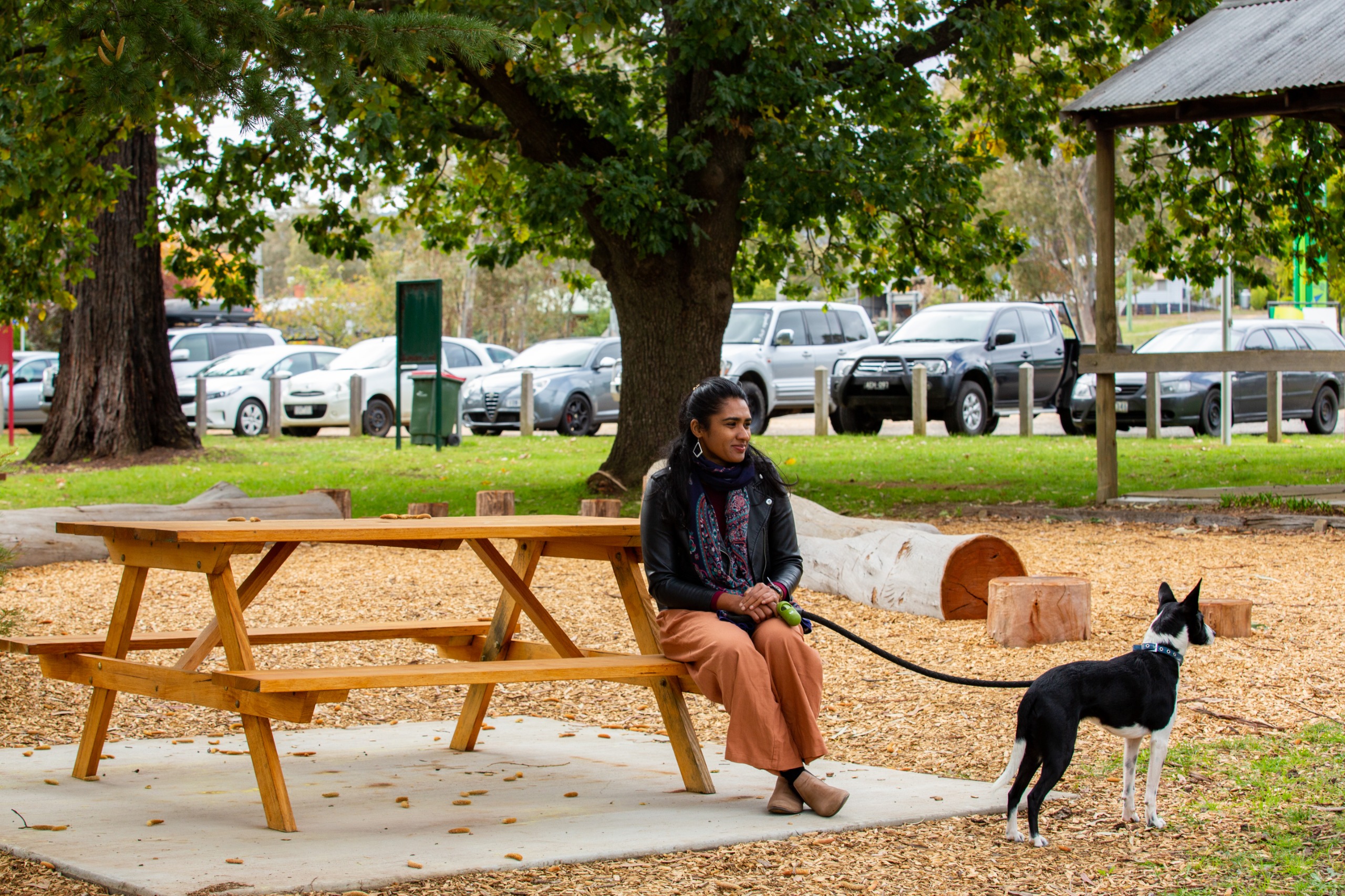 Woman seated at a picnic table with her dog.